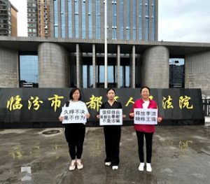 Linfen wives hold placards outside court