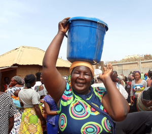 Nigerian IDP carrying aid bucket