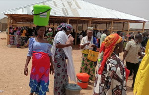 Woman with aid bucket in Zuru